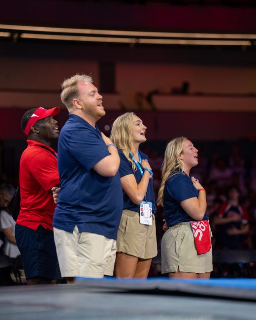 Mel Bull and coaches during the national anthem